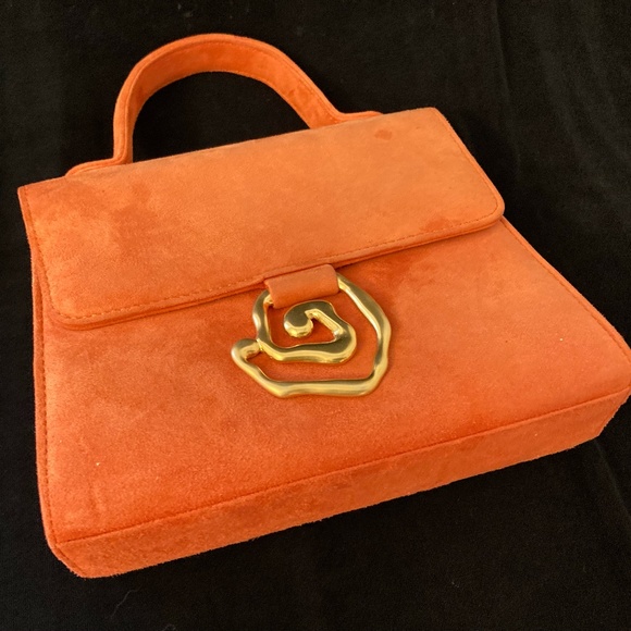 anne Klein Couture Handbags - Anne Klein Couture orange hand bag with gold circular design on the front.